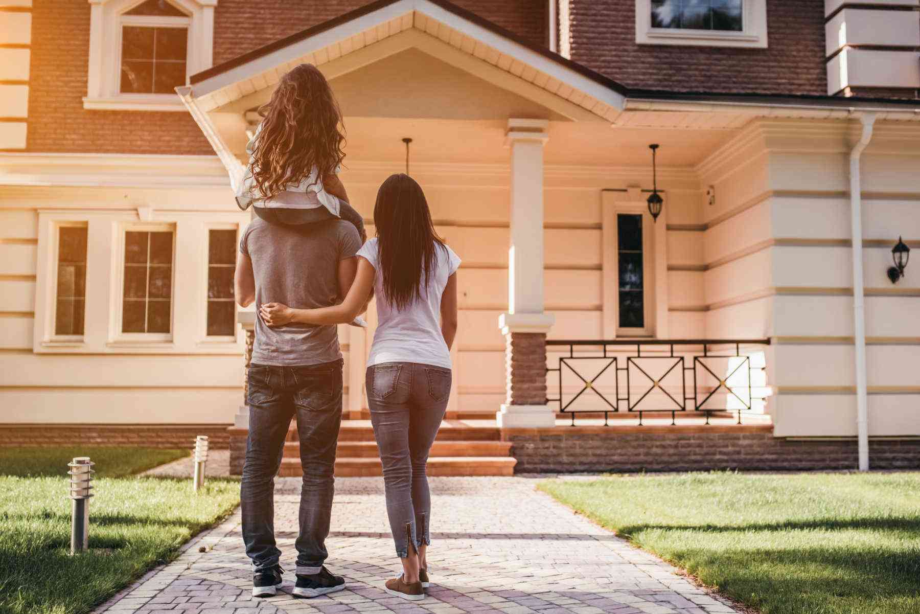 Happy couple with house in background